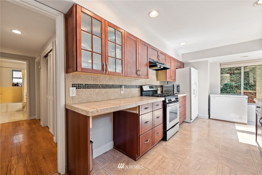 7611 Northeast 12th Street Medina, WA 98039 - Photo 10 of 23 a kitchen with stainless steel appliances granite countertop a stove a sink and a refrigerator