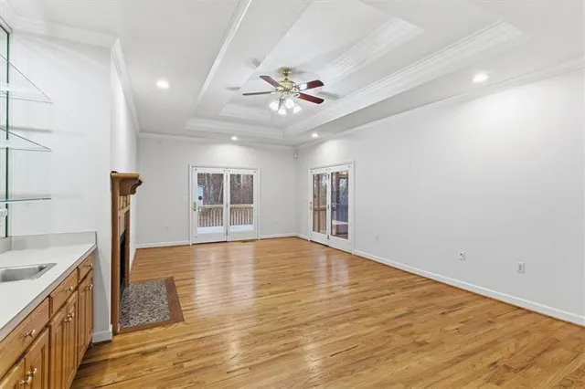 a view of an empty room with window and wooden floor