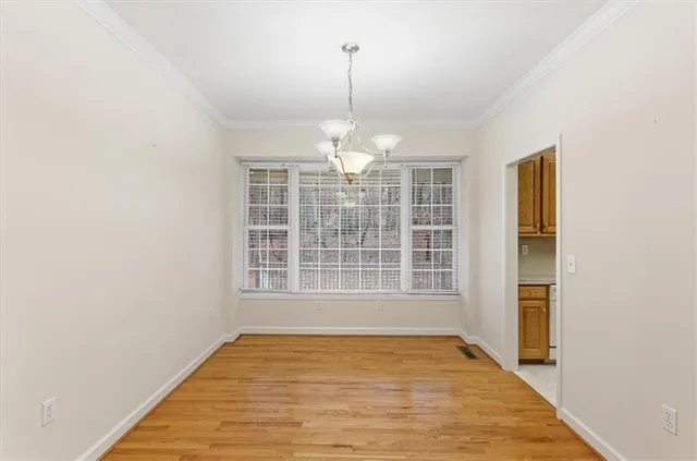 a view of a room with wooden floor and a ceiling fan