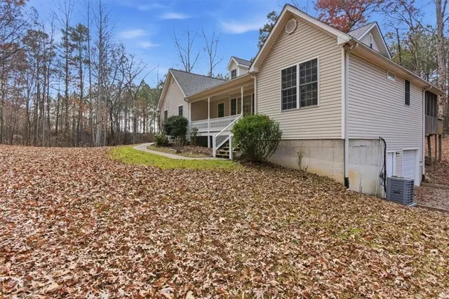 a backyard of a house with a garden and covered with trees