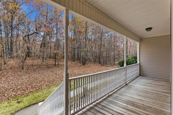 a view of an empty room with wooden floor fireplace and a window
