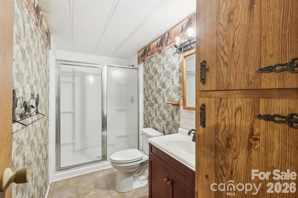 920 Dewitt Helms Road Monroe, NC 28112 - Photo 18 of 47 a bathroom with a shower curtain a sink and a toilet