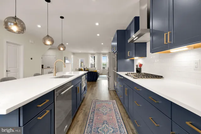 a large kitchen with stainless steel appliances granite countertop a lot of counter space and a sink