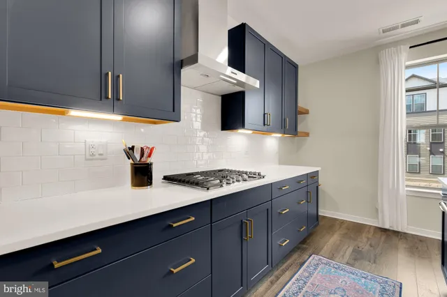 a kitchen with granite countertop a sink cabinets and a wooden floor