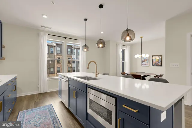 a kitchen with a sink a stove and a wooden floor