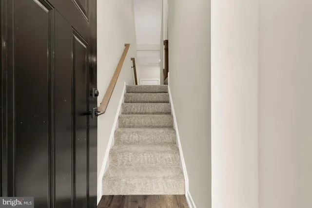 a view of staircase with white walls and white door
