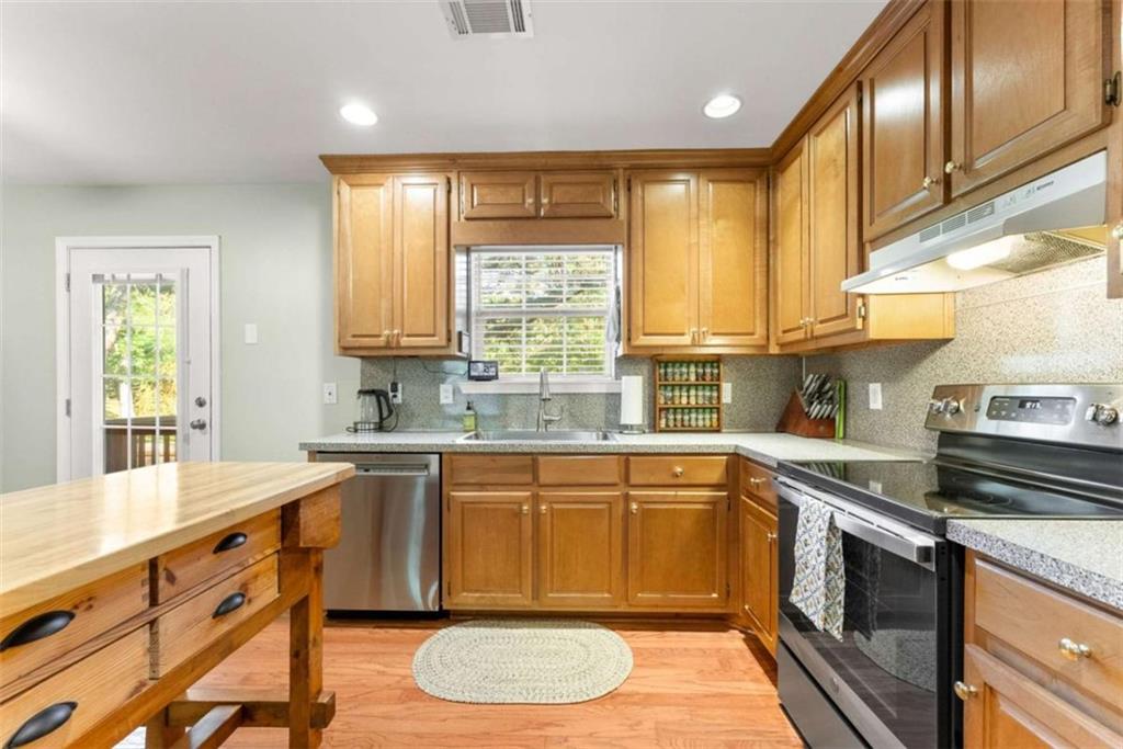 7210 Fields Drive Cumming, GA 30041 - Photo 20 of 58 a kitchen with stainless steel appliances granite countertop a sink a stove a refrigerator cabinets and a window