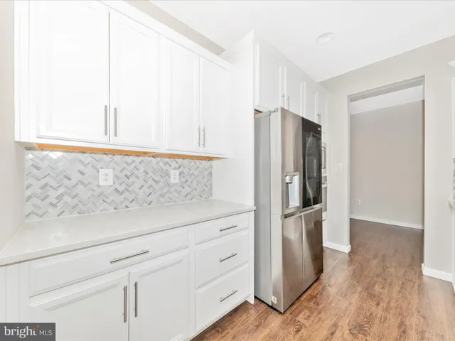 a kitchen with a stove a sink a window and wooden floor