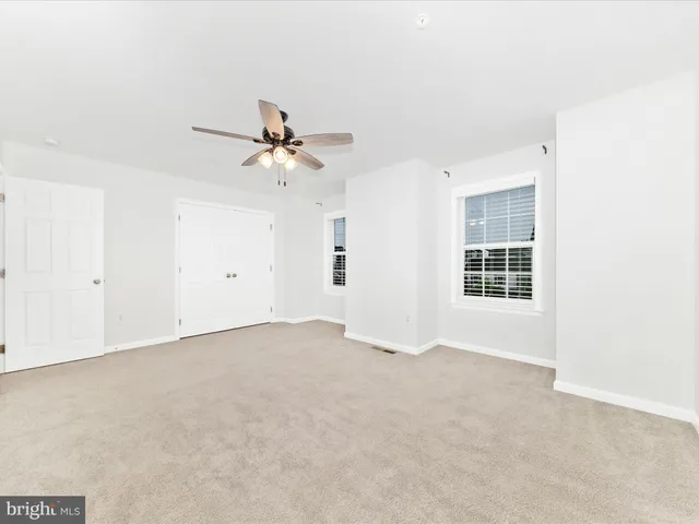 a view of a livingroom with a ceiling fan and window