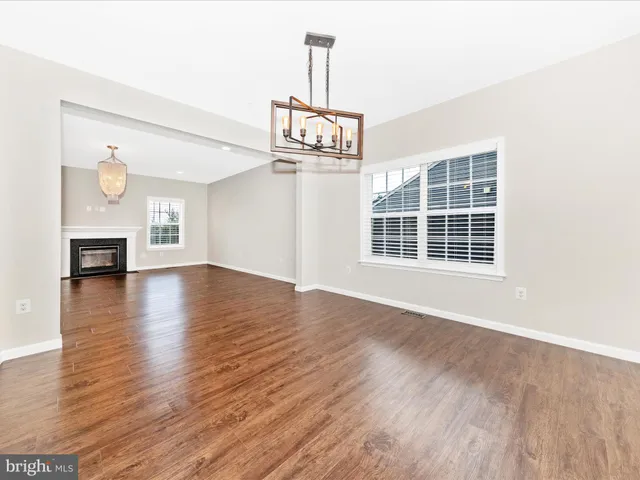 a view of empty room with wooden floor and fireplace