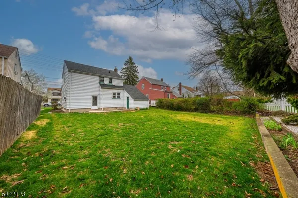 a view of a house with backyard and a tree