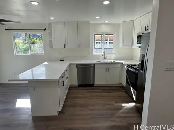 a large kitchen with stainless steel appliances granite countertop a sink stove and refrigerator