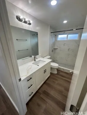 a spacious bathroom with a double vanity sink a toilet and a mirror