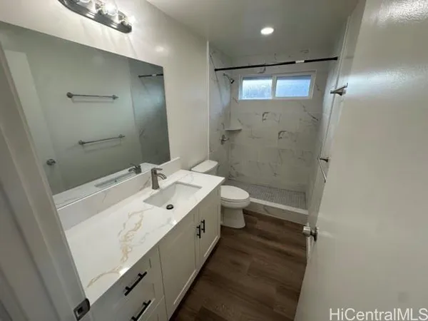 a bathroom with a sink a toilet and shower