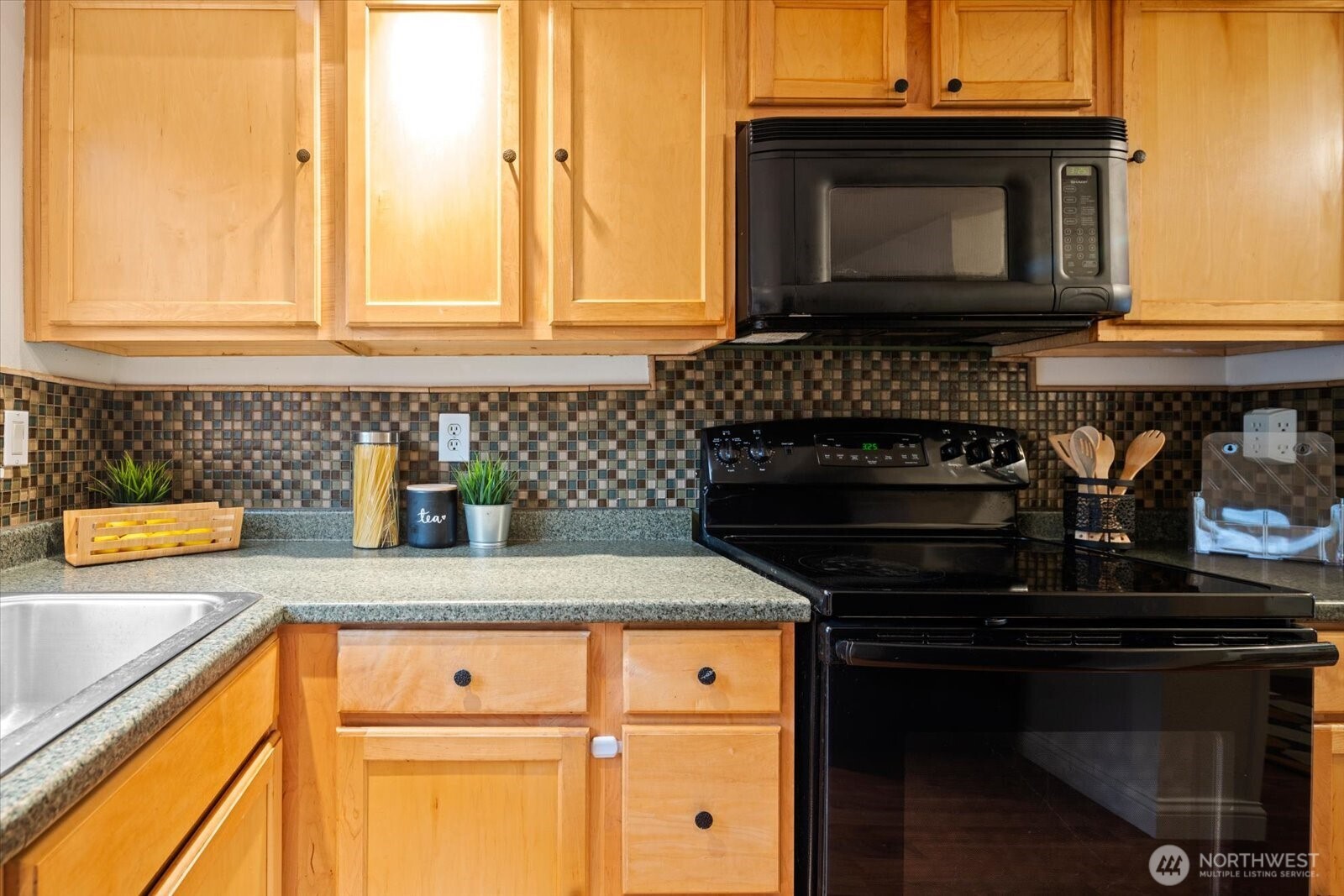 1600 Way E Yeslelr Way East, Unit 102 Seattle, WA 98122 - Photo 10 of 30 a kitchen with granite countertop a stove top oven microwave and cabinets