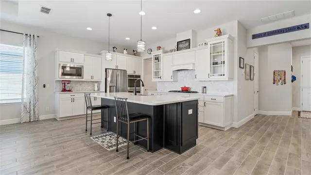 a kitchen with kitchen island granite countertop a sink cabinets and wooden floor