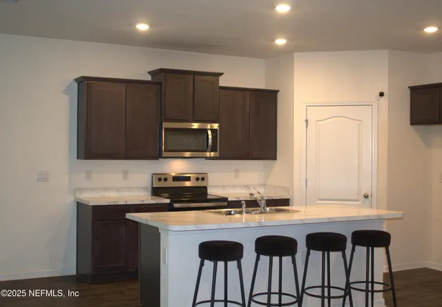 a kitchen with granite countertop a sink and a refrigerator