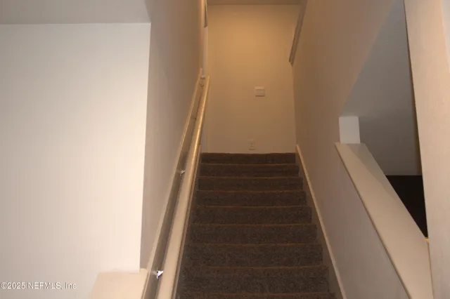 a view of staircase with white walls