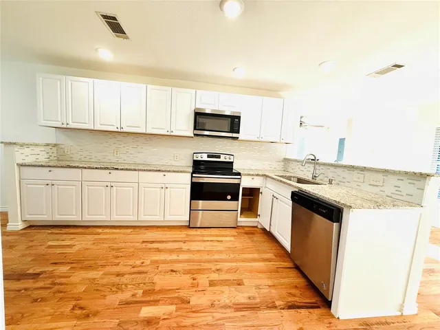 a kitchen with stainless steel appliances granite countertop a stove top oven and sink