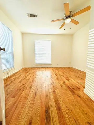 a bedroom with a bed and a chandelier fan