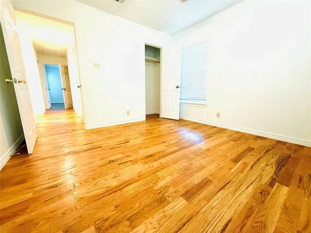 a view of an empty room with chandelier fan and a window