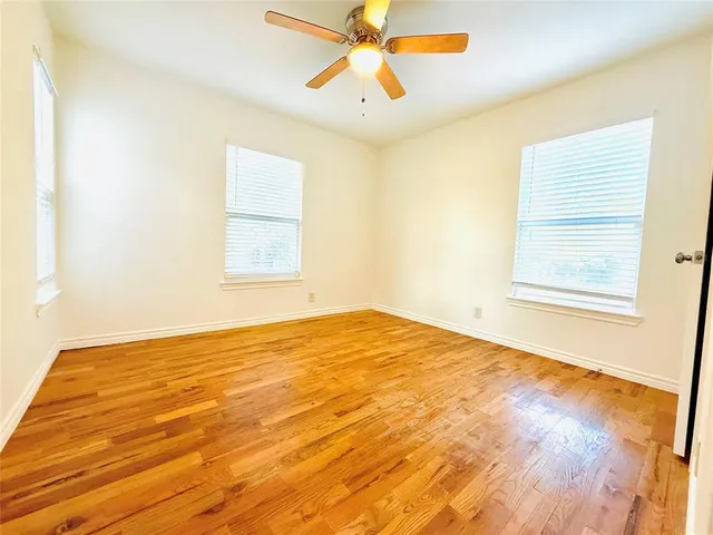 a view of a big room with wooden floor and a ceiling fan