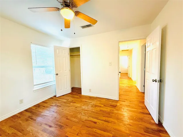 a view of a big room with windows and chandelier fan