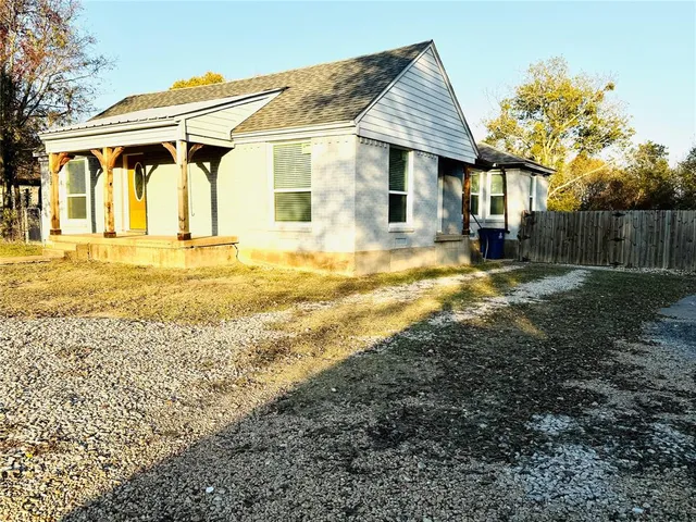 a view of a house with backyard and wooden fence
