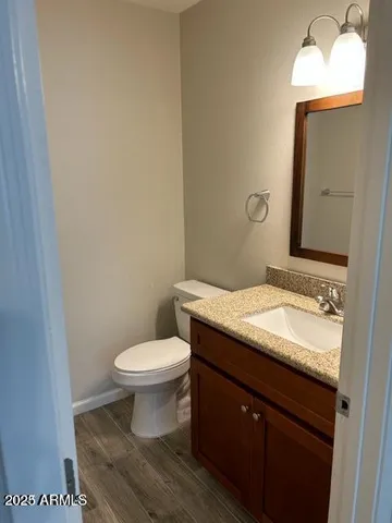 a bathroom with a granite countertop toilet a sink and a mirror