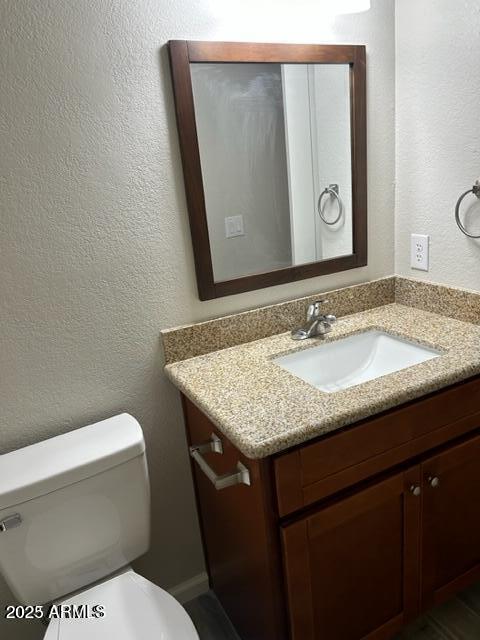 9832 East La Palma Avenue, Unit 2 Gold Canyon, AZ 85118 - Photo 20 of 24 a bathroom with a granite countertop toilet sink and mirror