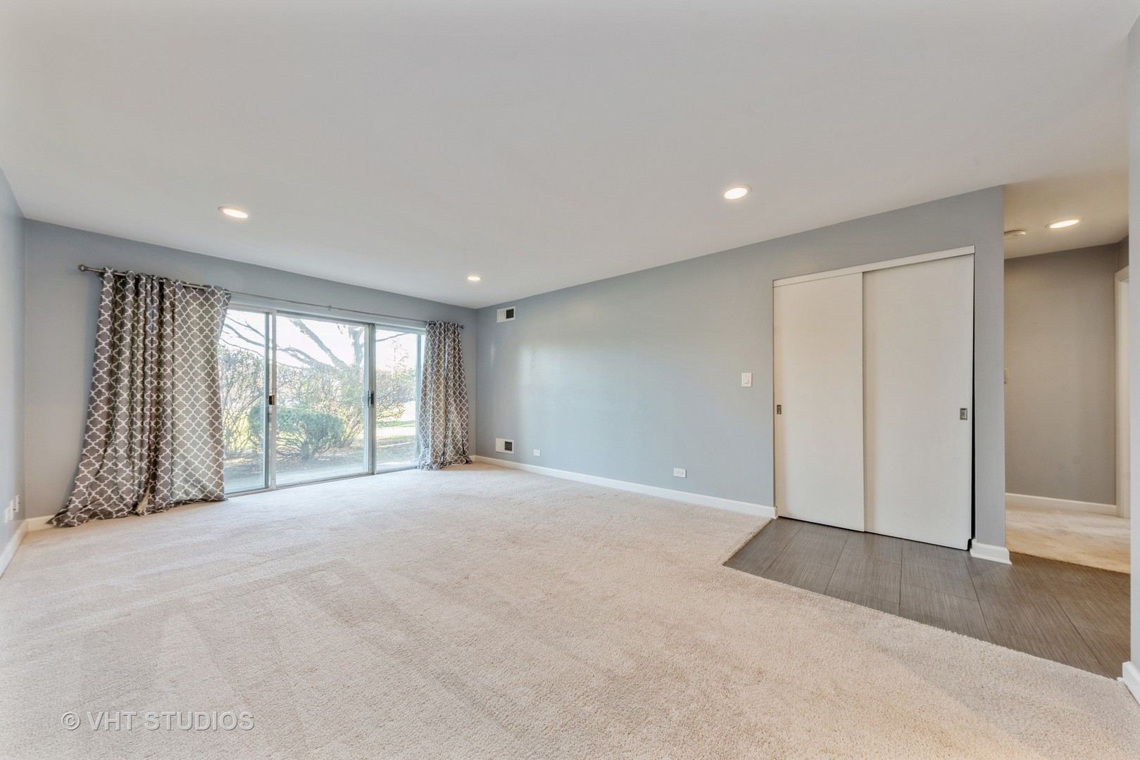 5100 Carriageway Drive, Unit 109 Rolling Meadows, IL 60008 - Photo 5 of 12 a view of an empty room with wooden floor and a window