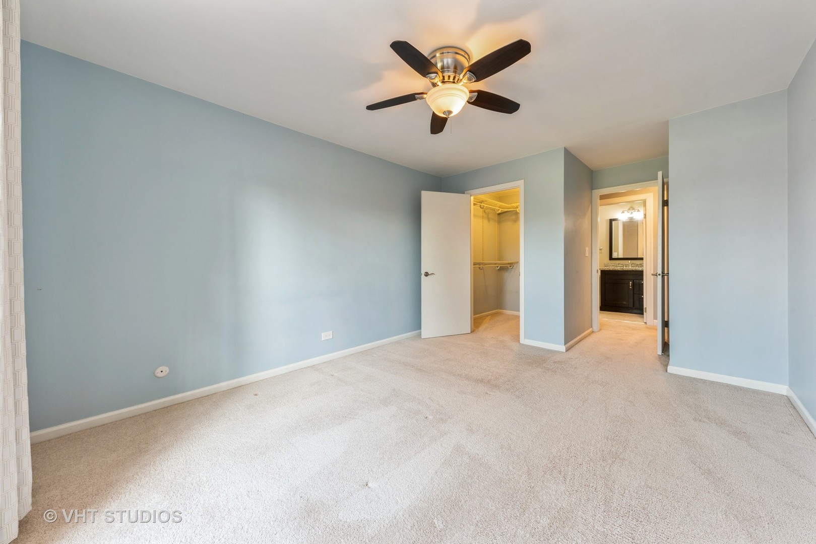 5100 Carriageway Drive, Unit 109 Rolling Meadows, IL 60008 - Photo 10 of 12 an empty room with a ceiling fan and a window