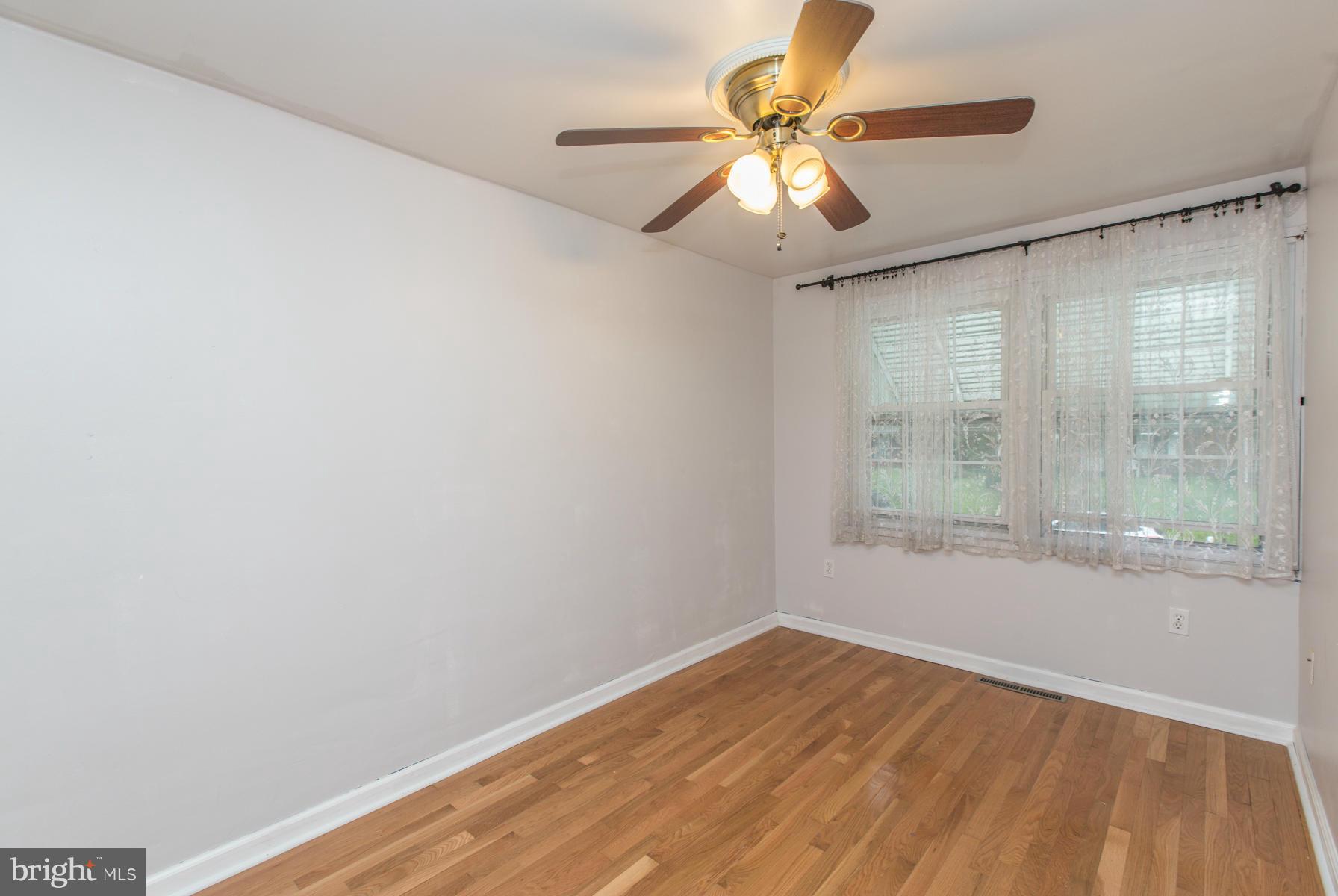 8009 Wynbrook Road Baltimore, MD 21224 - Photo 14 of 27 wooden floor in an empty room with a window