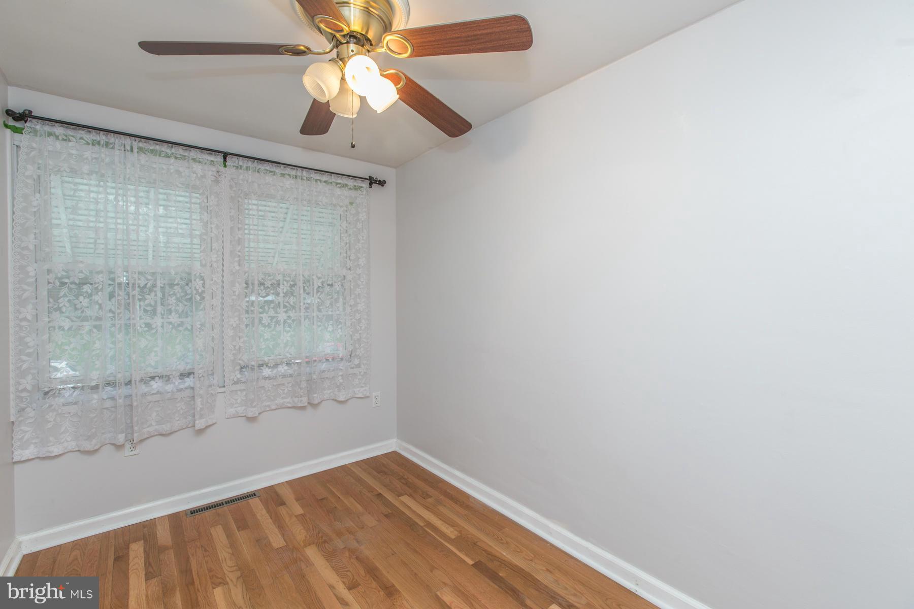 8009 Wynbrook Road Baltimore, MD 21224 - Photo 16 of 27 a view of a room with wooden floor and a ceiling fan