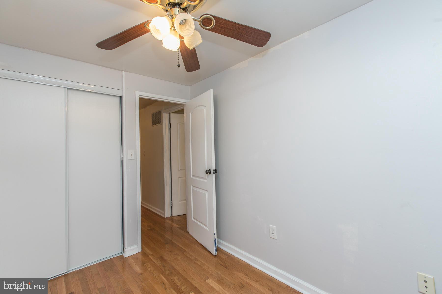 8009 Wynbrook Road Baltimore, MD 21224 - Photo 17 of 27 a view of hallway with wooden floor and ceiling fan