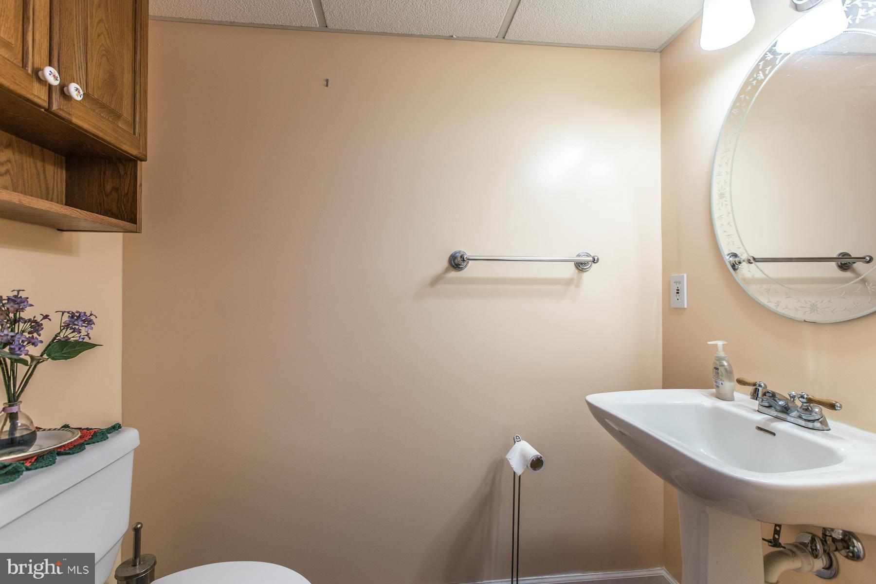 8009 Wynbrook Road Baltimore, MD 21224 - Photo 19 of 27 a bathroom with a sink a toilet and mirror