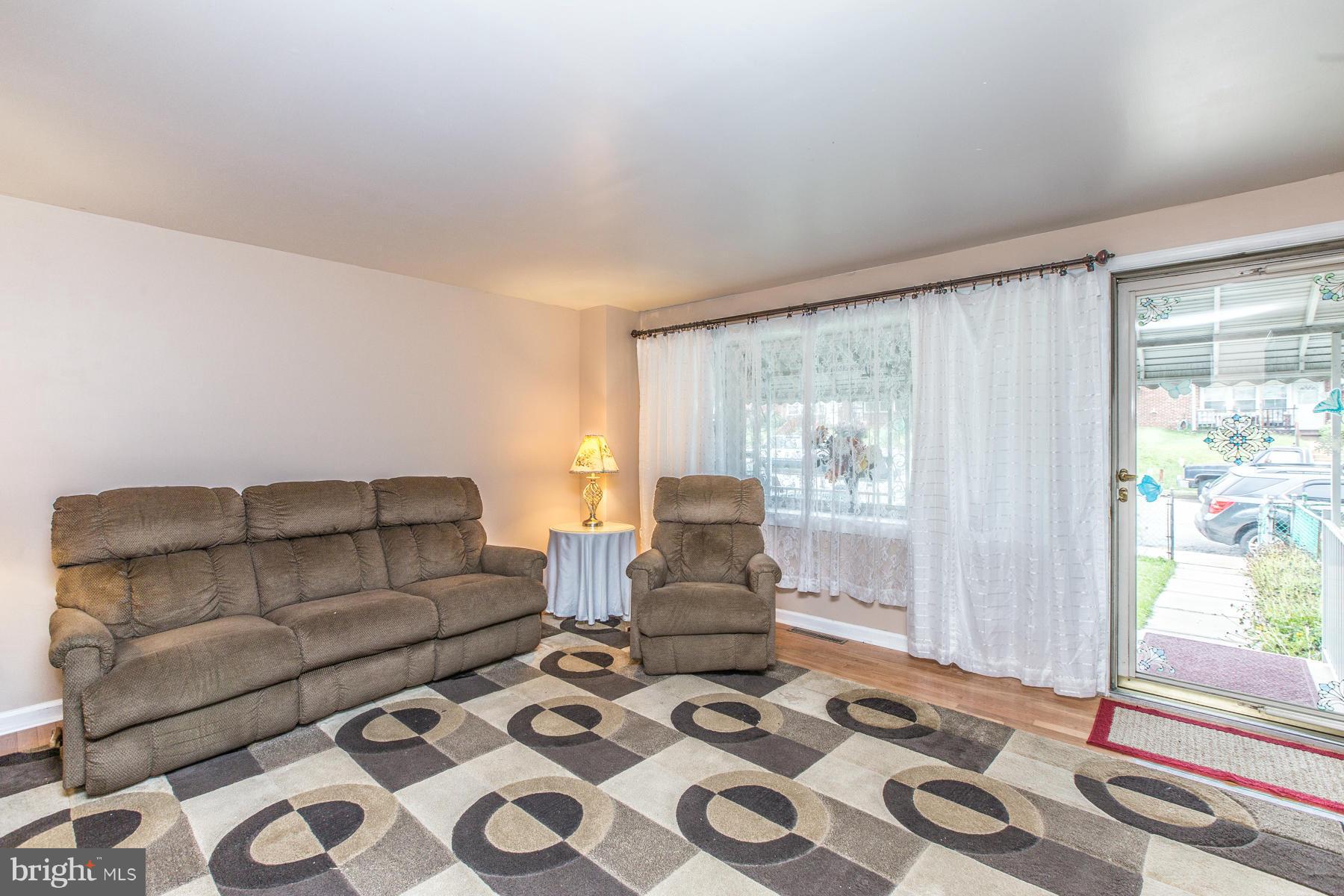 8009 Wynbrook Road Baltimore, MD 21224 - Photo 7 of 27 a living room with furniture and a floor to ceiling window