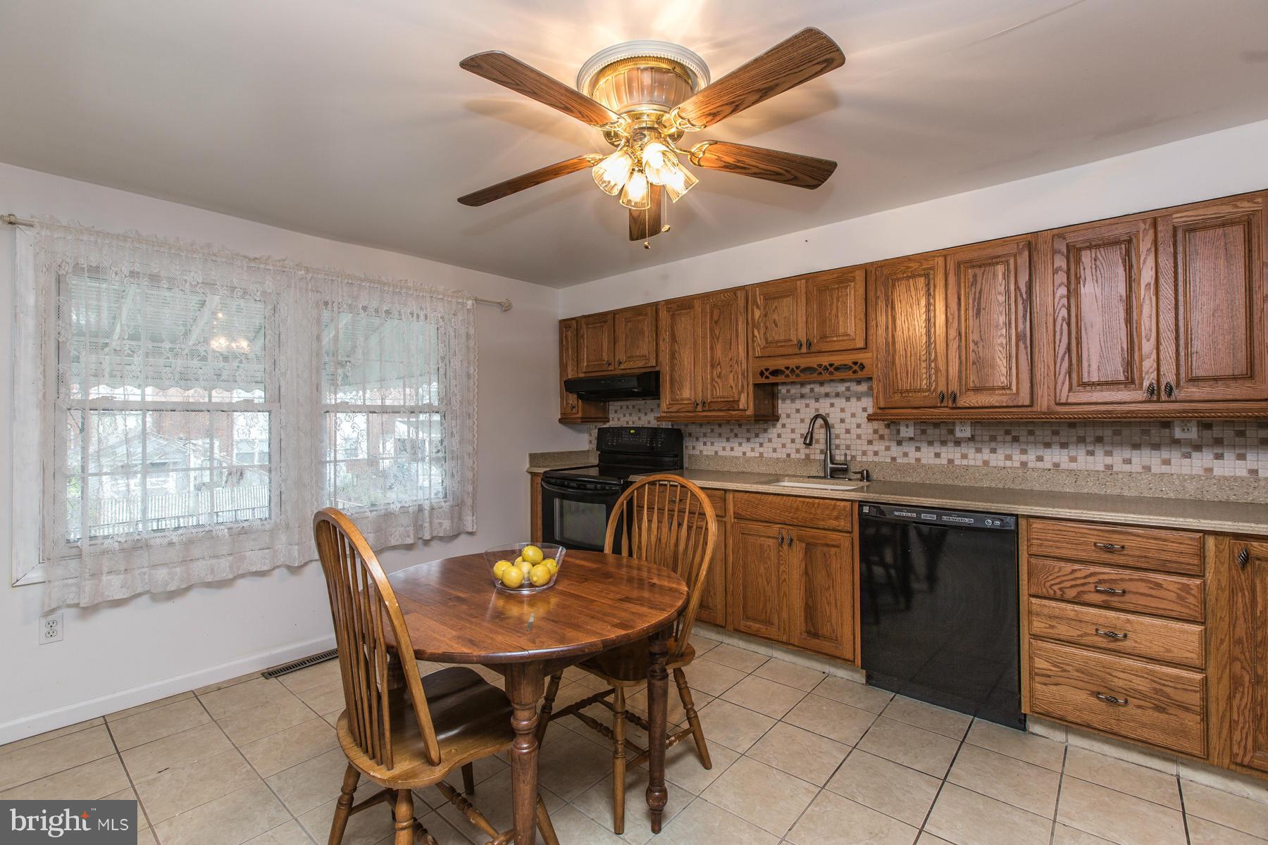 8009 Wynbrook Road Baltimore, MD 21224 - Photo 9 of 27 a kitchen with a cabinets appliances and a dining table