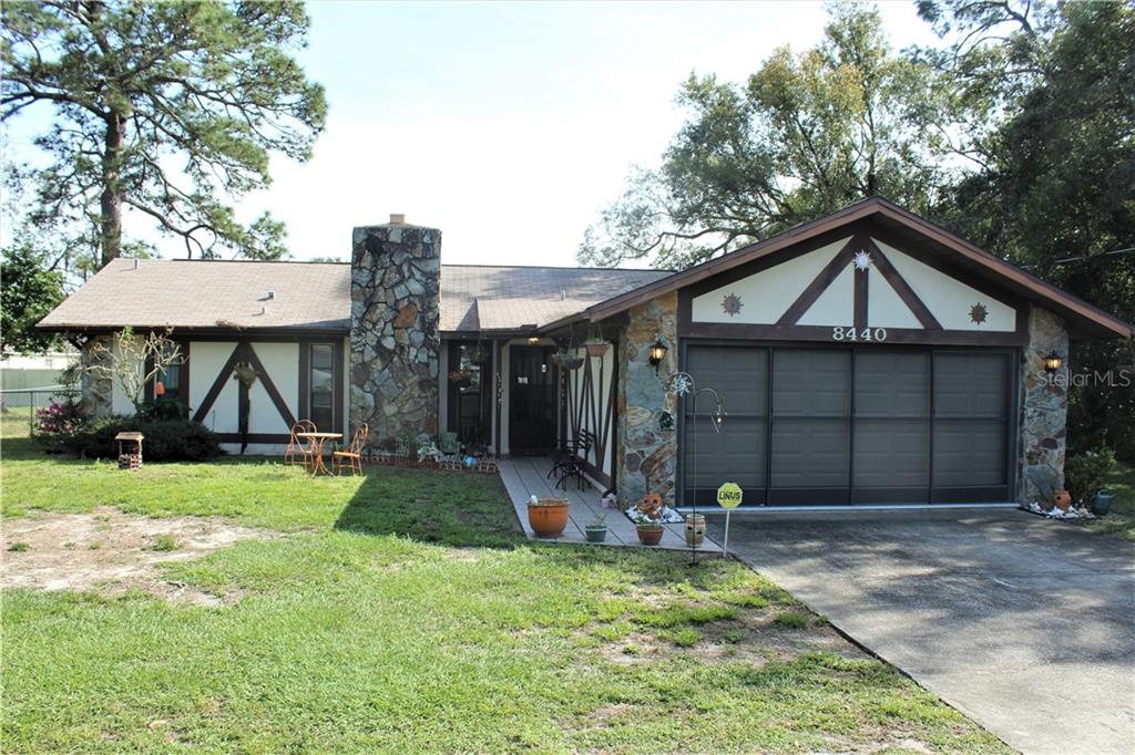 8440 Spring Hill Drive Spring Hill, FL 34608 - Photo 1 of 1 a front view of a house with garden