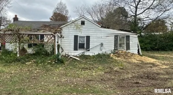 a front view of house with yard and trees in the background