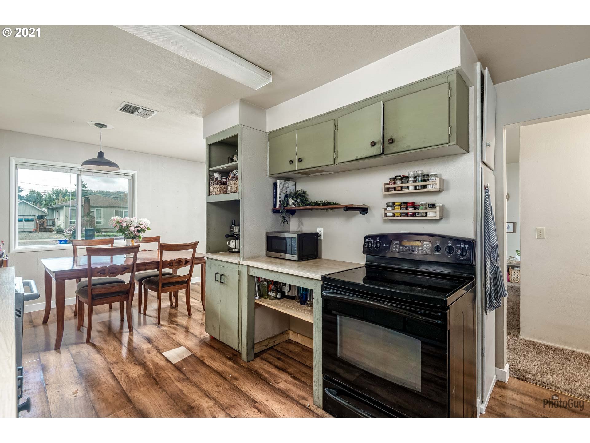 1872 I Street Springfield, OR 97477 - Photo 14 of 24 a kitchen with stainless steel appliances a stove a sink cabinets and a dining table