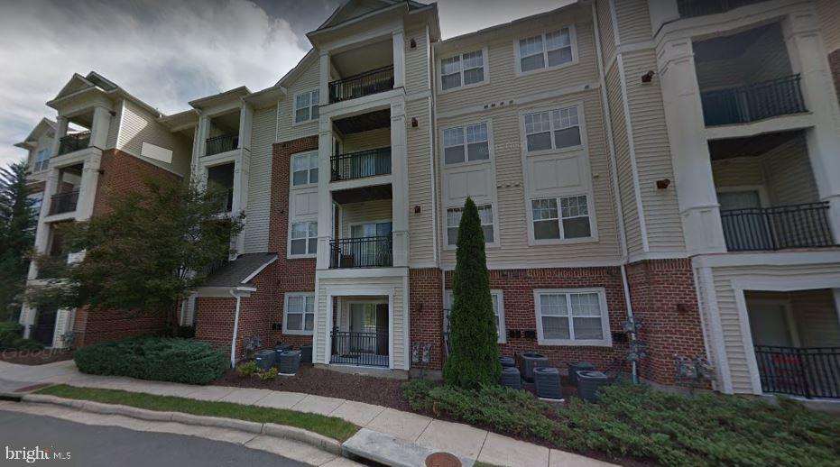12958 Centre Park Circle, Unit 325 Herndon, VA 20171 - Photo 1 of 13 a front view of a multi story building with yard
