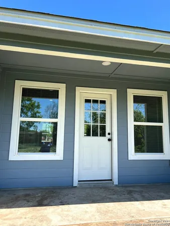 a view of a house with a tree and wooden fence