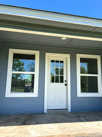 a view of a house with a tree and wooden fence