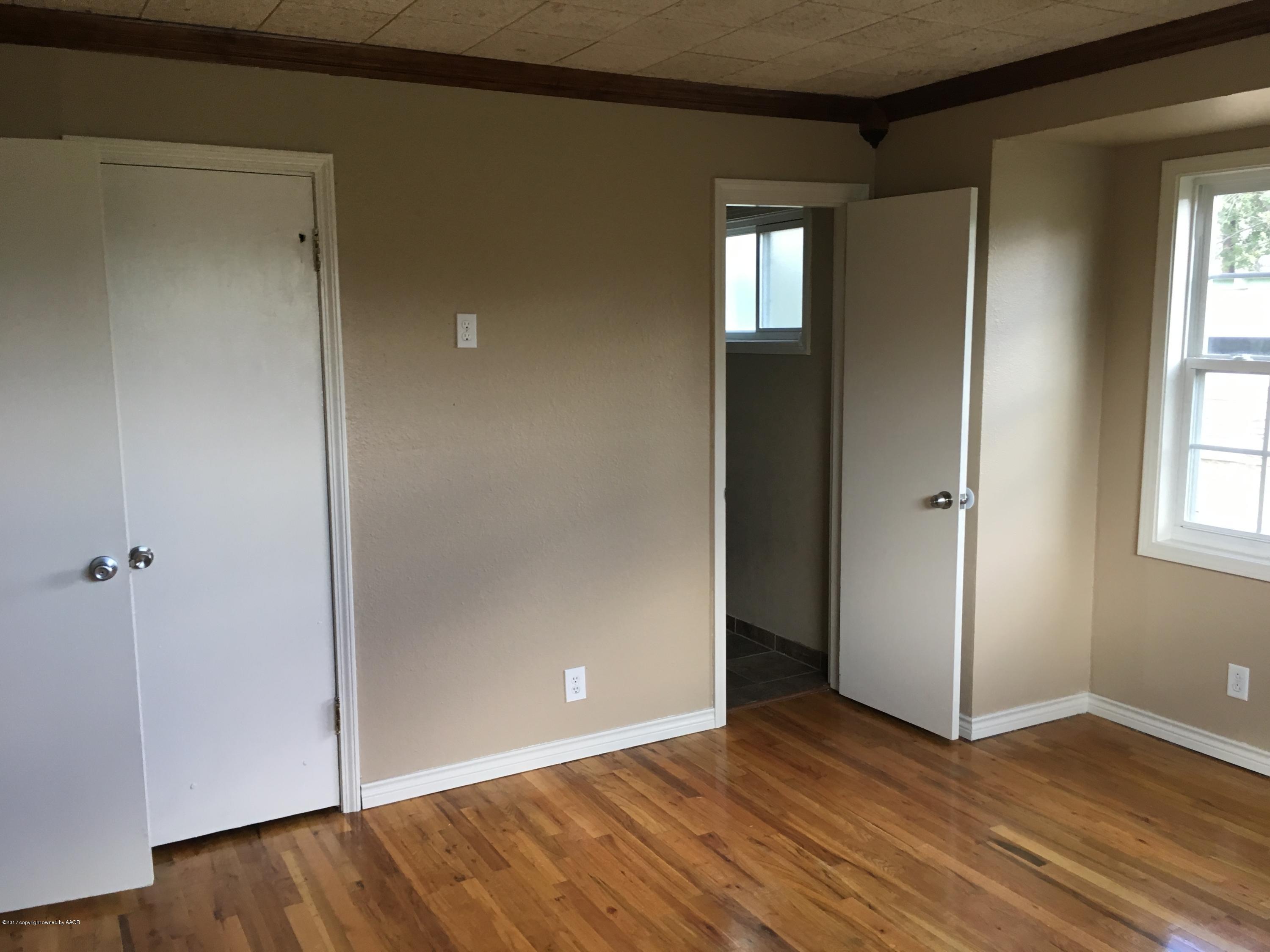4651 Crockett Street Amarillo, TX 79110 - Photo 8 of 18 an empty room with wooden floor and windows