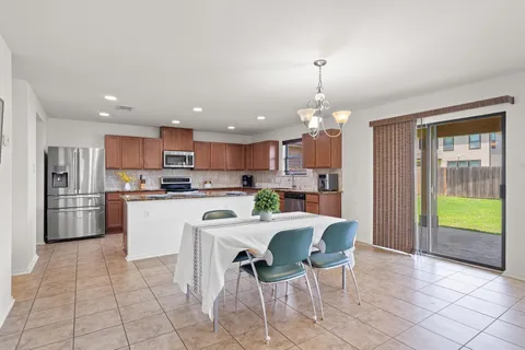 a kitchen with stainless steel appliances kitchen island granite countertop a refrigerator and a stove top oven