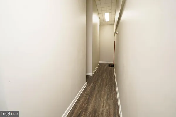 a view of a hallway with wooden floor and a painting