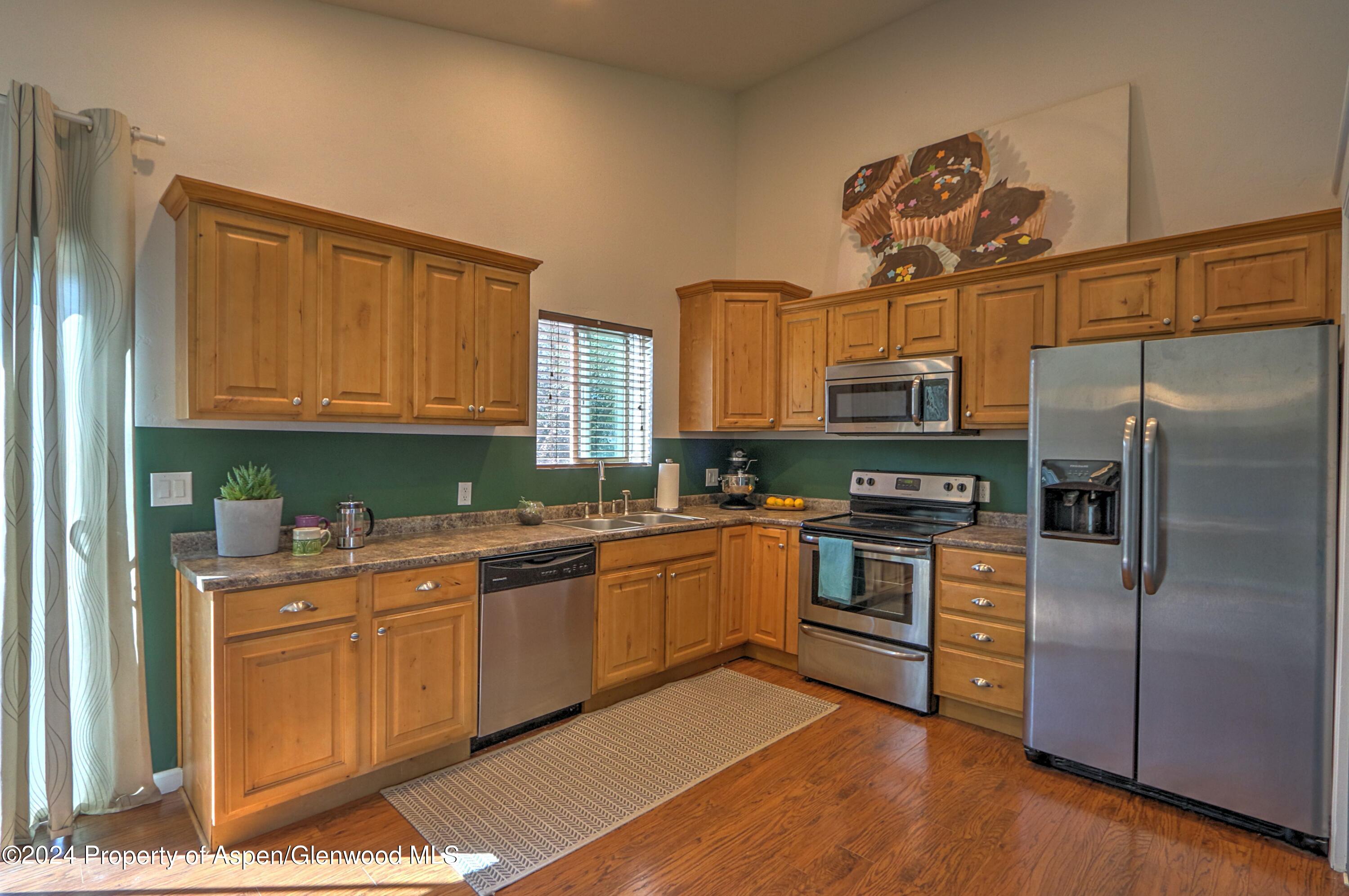 1329 East 8th Street Rifle, CO 81650 - Photo 12 of 26 a kitchen with a sink stainless steel appliances cabinets and a window
