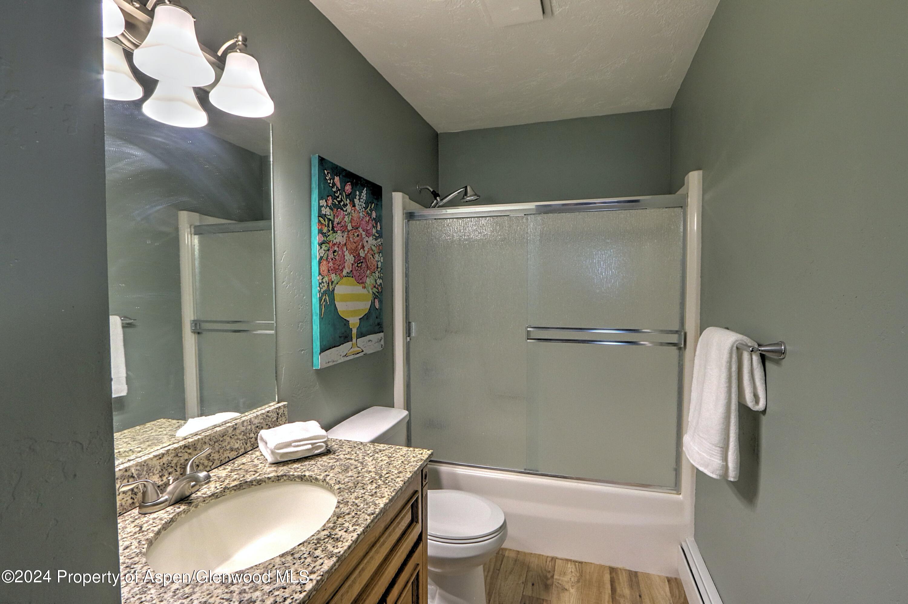 1329 East 8th Street Rifle, CO 81650 - Photo 19 of 26 a bathroom with a granite countertop sink toilet and shower