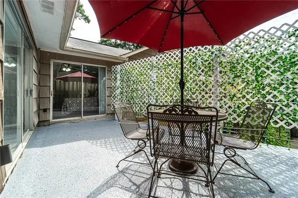 a patio with a table and chairs under an umbrella